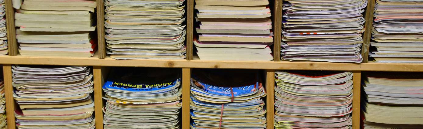Canadian student holding a stack of Staples flyers in an office-supply aisle