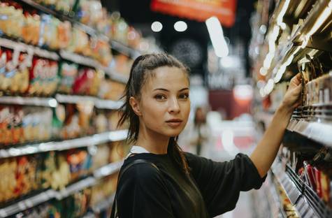 Canadian shopper using a smartphone app to track grocery loyalty bonus events and plan a shopping calendar