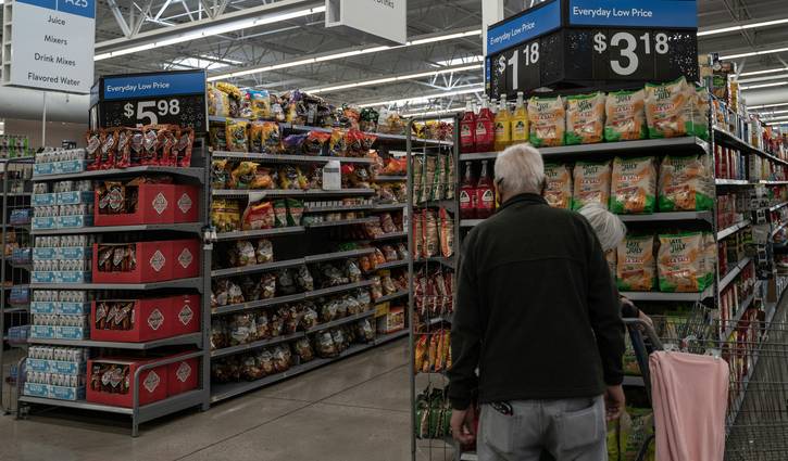 Canadian Walmart shoppers looking for sales and clearance in a bright store aisle