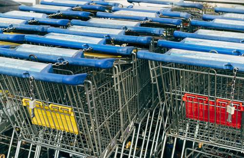 Canadian shopper at Walmart checkout using app and paper coupons for maximum discount