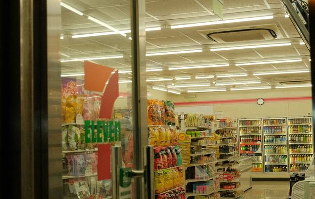 Canadian shopper using Walmart My Offers app on phone in grocery aisle for digital savings