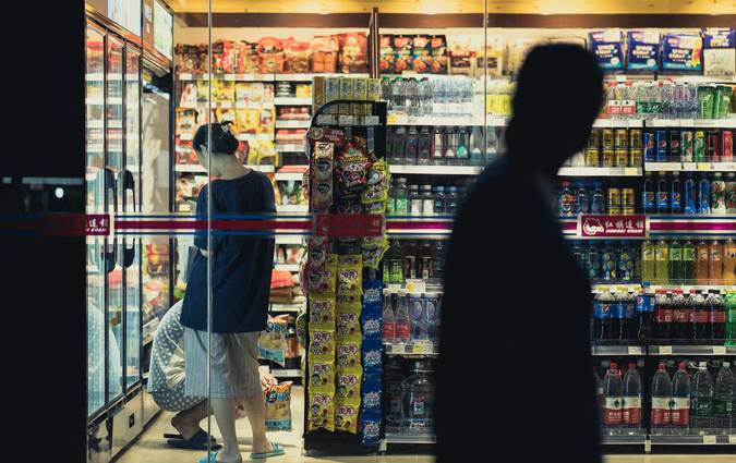 Canadian shopper showing a competitor grocery flyer to Walmart cashier for price match